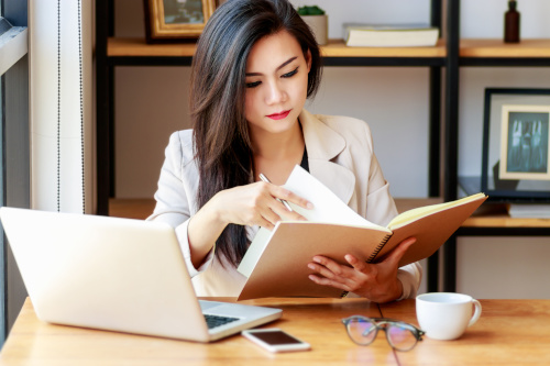 A woman goes through papers getting ready for work.